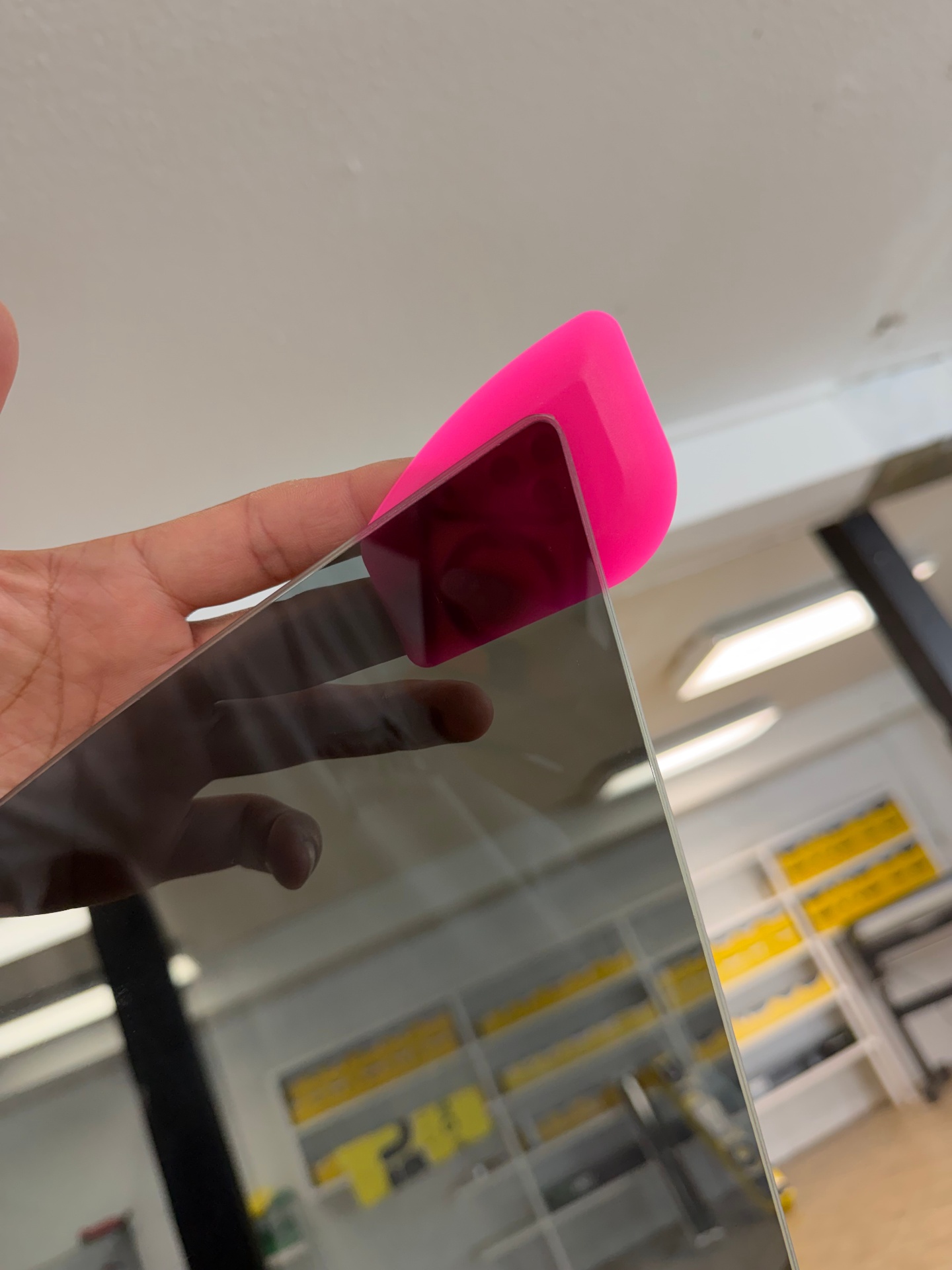 Squeegee pressing tint film onto glass in the shop